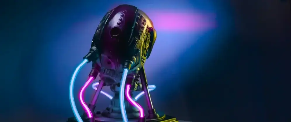 The image shows the back view of a sculpture titled “VOLTA” from the PROJECT AD-01 series by Freaky Deek. The sculpture depicts a futuristic android with a sleek, metallic body. The back of the android is detailed with smooth surfaces and intricate mechanical elements. Purple LED lights illuminate various sections, particularly along the spine, highlighting the contours and giving the sculpture a glowing, high-tech appearance. The dark background contrasts with the bright lights, making the illuminated details stand out vividly.
